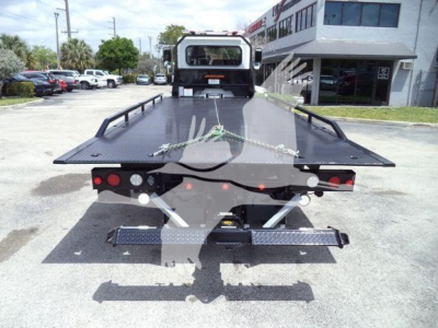 Back view of a 2018 Peterbilt 337 rollback tow truck flatbed with rear lights and hydraulic system visible.