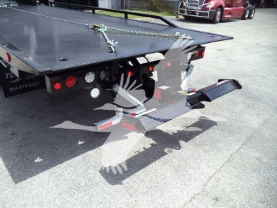 Peterbilt 337 rollback truck rear view showing flatbed with diamond plate, rear ramps, and taillights.