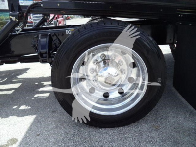 Peterbilt 337 rollback truck wheel and chrome rim showing hub and tire with undercarriage components visible.