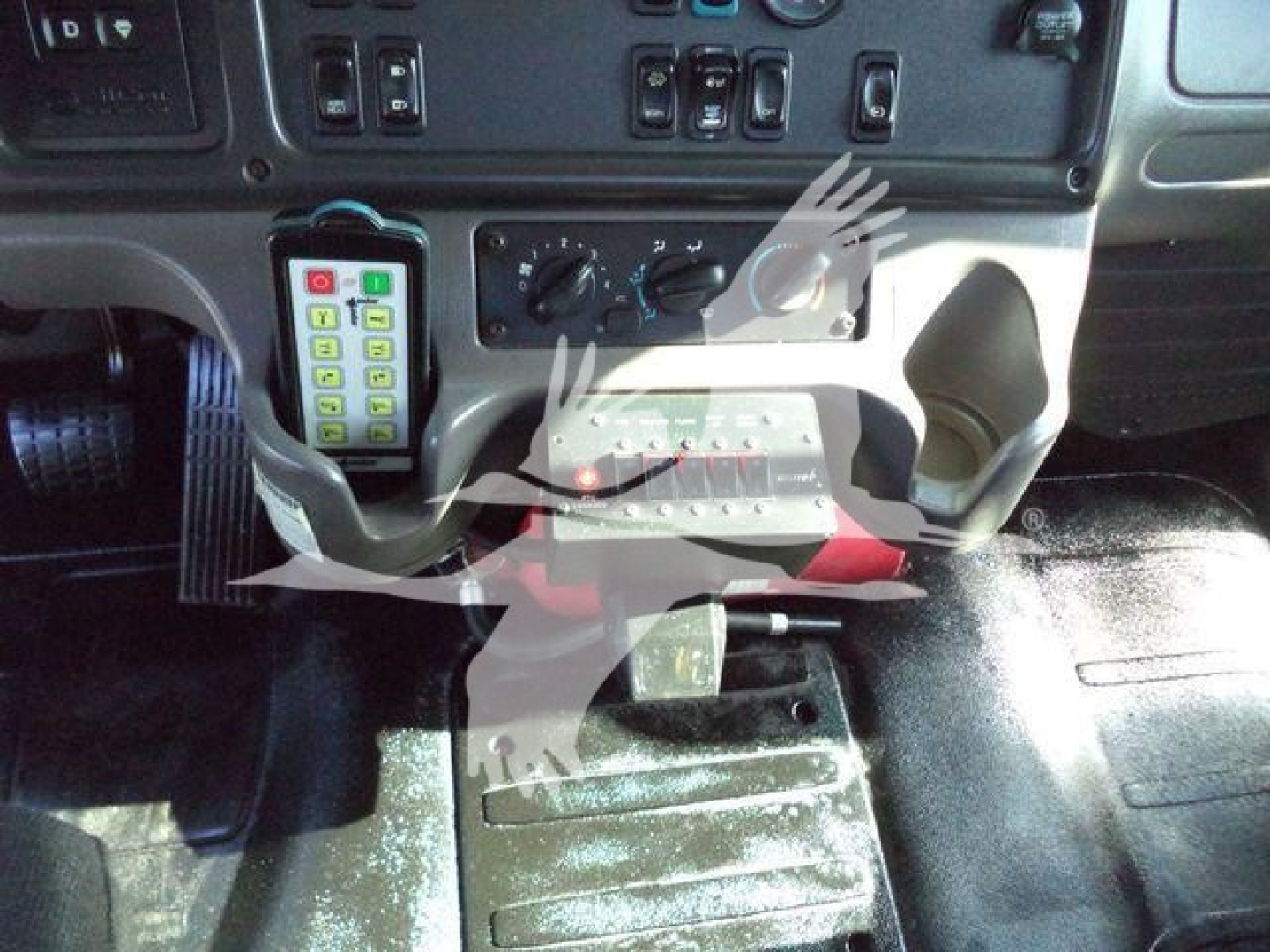 Freightliner M2-106 instrument panel and driver footwell area with control switches and keypad visible