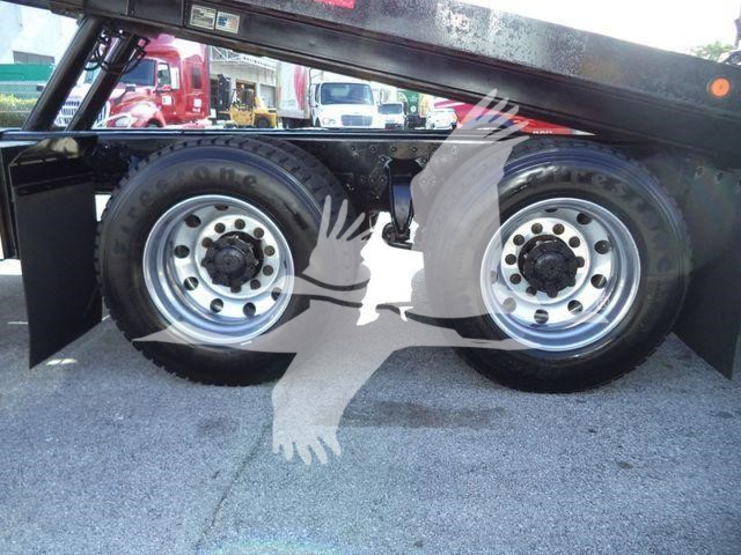 Rear section showing dual wheels on Freightliner M2 106 rollback truck under flatbed with chrome rims and tires.