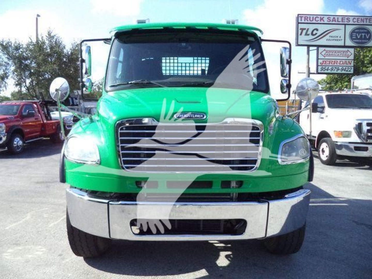 Green 2016 Freightliner M2 106 front view with chrome grille and bumper, roll-back truck in dealership lot