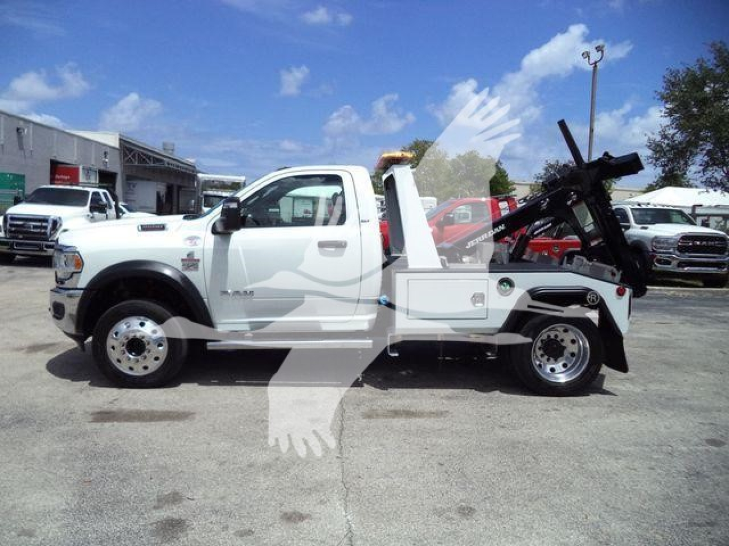 Ram 4500 tow truck side view showing winch equipment and hydraulic arm with white cab and flatbed, stock number T83037FM, category winch.