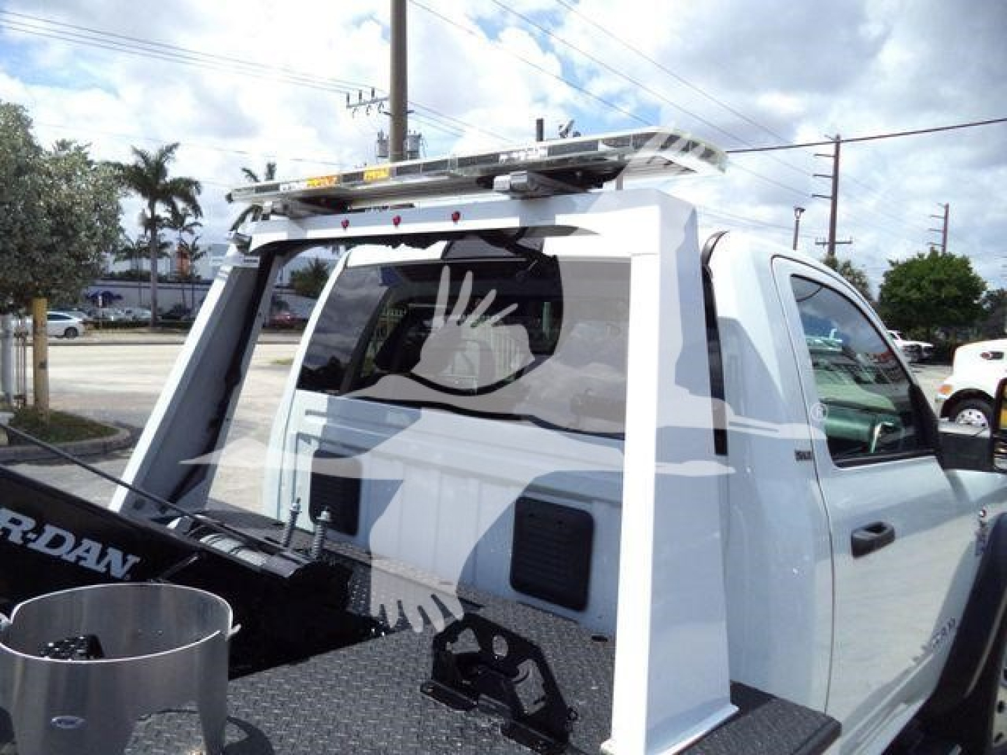Truck cab rear with a winch mount and ladder rack; white Ram 4500 SLT; stock number T83037FM; rear window guards; roof top ladder rack and winch-related equipment visible.