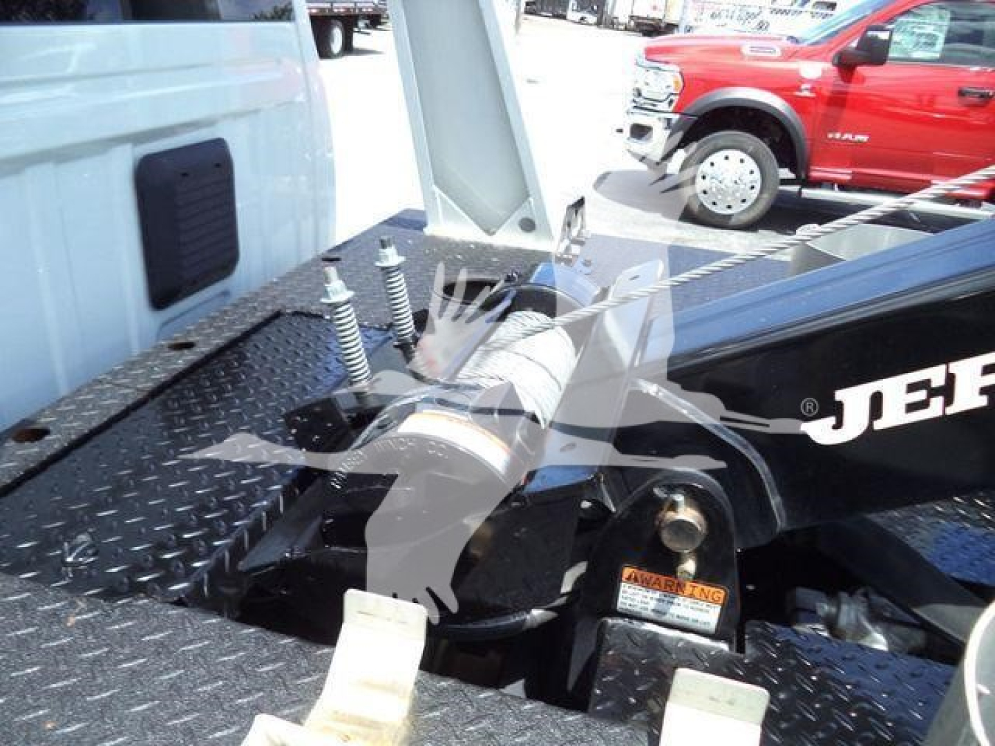 Truck bed area showing winch mount and towing hitch on a RAM 4500 style pickup with diamond plate surface.