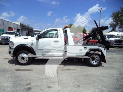 Ram 4500 tow truck side view showing winch equipment and hydraulic arm with white cab and flatbed, stock number T83037FM, category winch.
