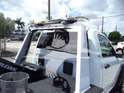 Truck cab rear with a winch mount and ladder rack; white Ram 4500 SLT; stock number T83037FM; rear window guards; roof top ladder rack and winch-related equipment visible.