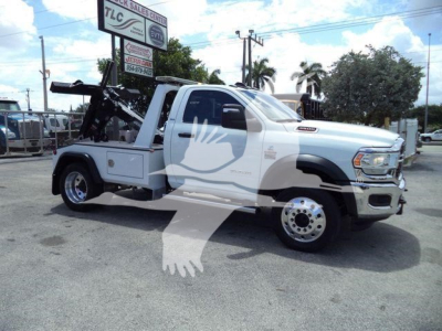 Ram 4500 tow truck in service with crane and winch, side view, white with gray graphics.