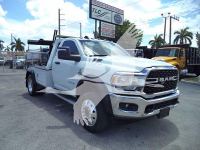 Ram 4500 dual rear wheel pickup truck with crane/utility bed, white exterior, front grille RAM emblem, dealership lot in background.