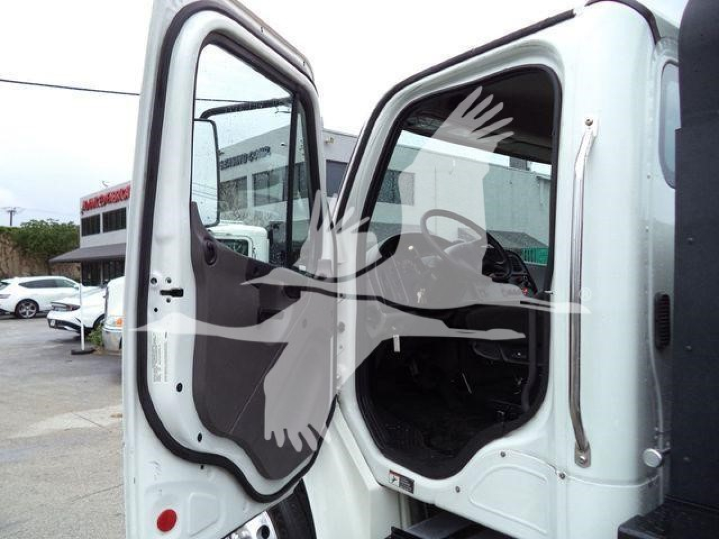 Cab interior and open door of a Freightliner M2 106 roll-back truck showing cabin area and driver door.