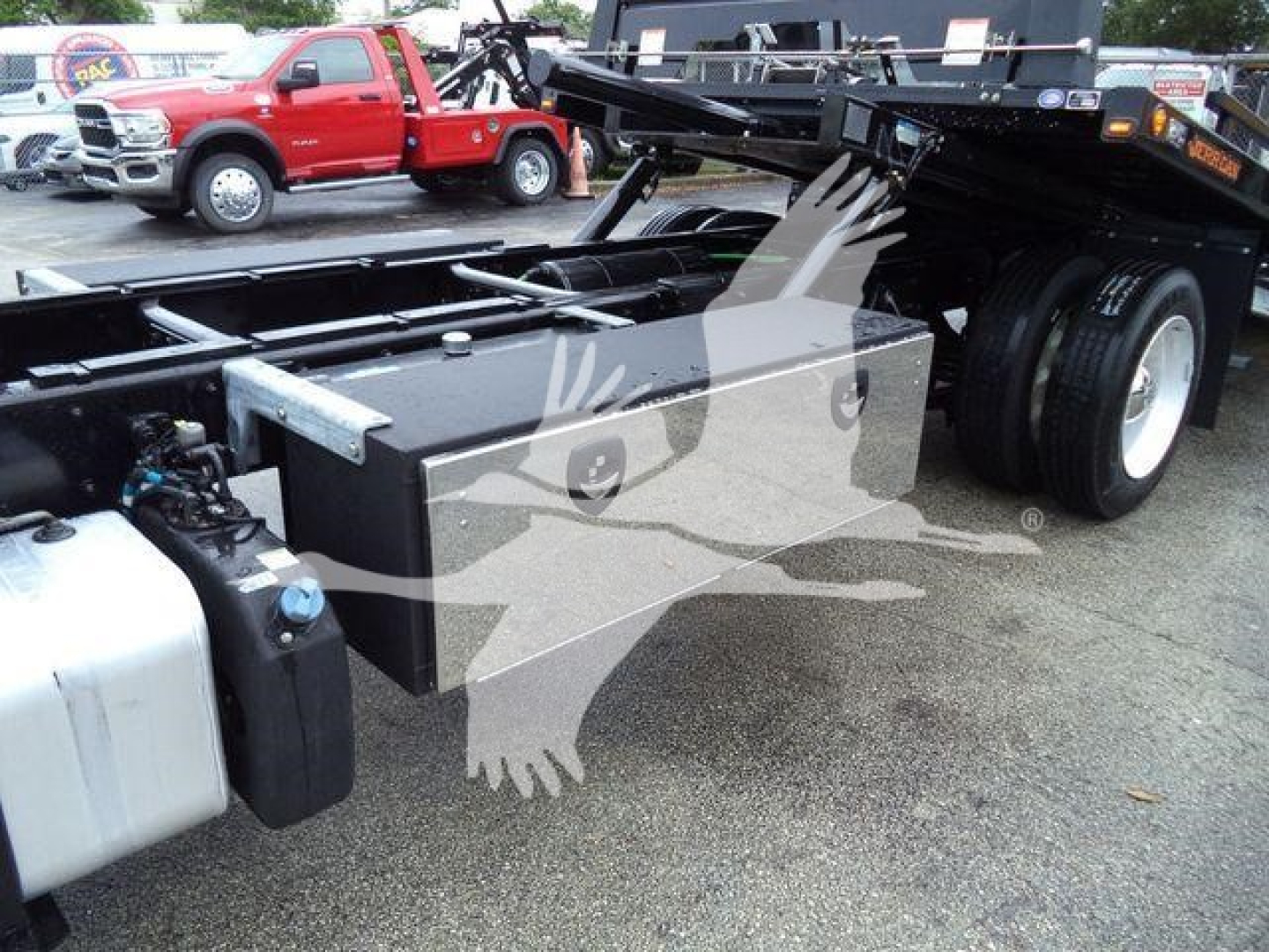 Truck chassis with horizontal toolbox and fuel tank visible, Freightliner M2 106 rollback setup showing undercarriage and wheels.