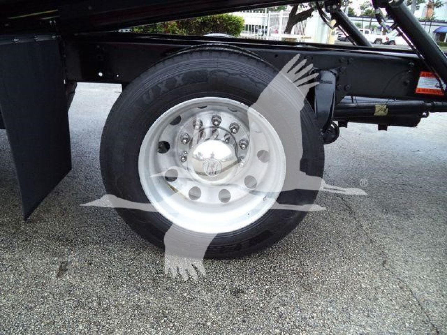 Wheel and tire close-up on Freightliner M2 106 rollback chassis showing steel wheel and tire with hub cap.