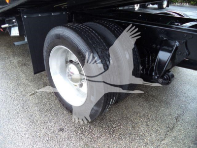 Truck rear dual wheels and suspension of a 2020 Freightliner M2 106 rollback unit showing dual rear tires and chassis components.