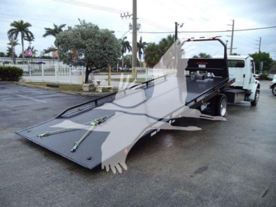 Truck bed in loading position showing flatbed and rear of Freightliner M2 106.