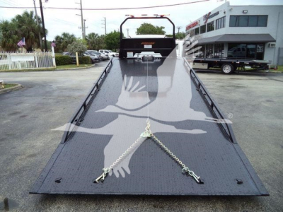 Truck bed of a Freightliner M2 106 rollback showing metal platform with chains and rear winch area.
