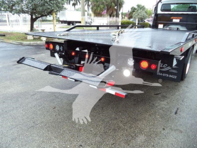 Rear view of a Freightliner rollback truck bed with folded double-tier lift/ramps and taillights visible.