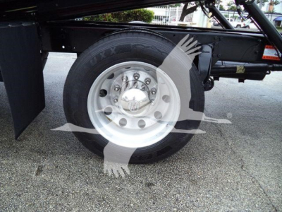 Wheel and tire close-up on Freightliner M2 106 rollback chassis showing steel wheel and tire with hub cap.