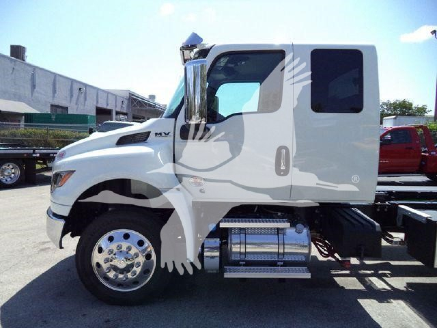 International MV rollback truck cab side view showing chrome fuel tanks and steps