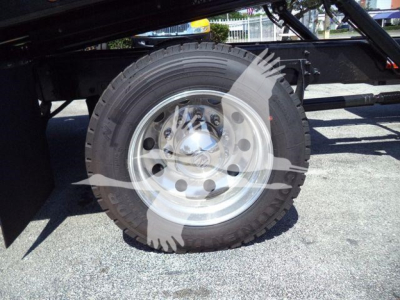 Truck wheel and tire on a rollback chassis showing a steel rim and tire tread with a partial side frame.