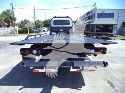 Flatbed tow truck or rollback bed rear view showing platform and taillights with bumper steps.