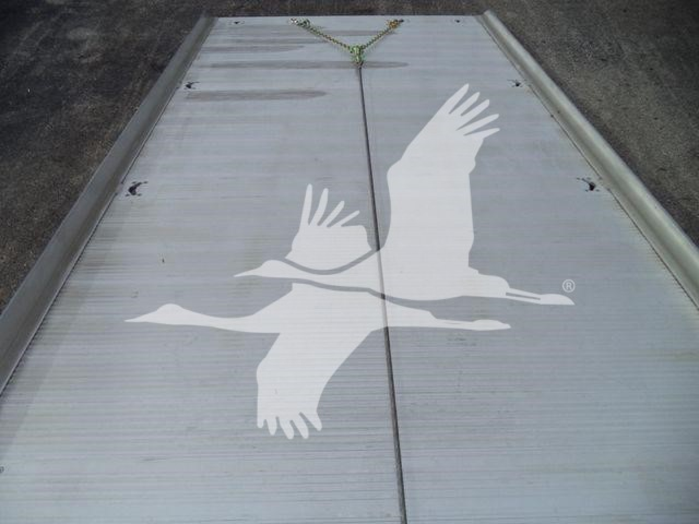 Trailer or flatbed with a large white gull graphic on a metallic surface, hanging straps at top center, showing a seagull emblem.