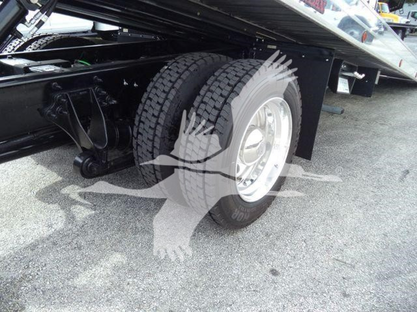 Truck rear dual tires and suspension undercarriage of the 2026 International MV rollback truck showing dual rear wheels and undercarriage components.