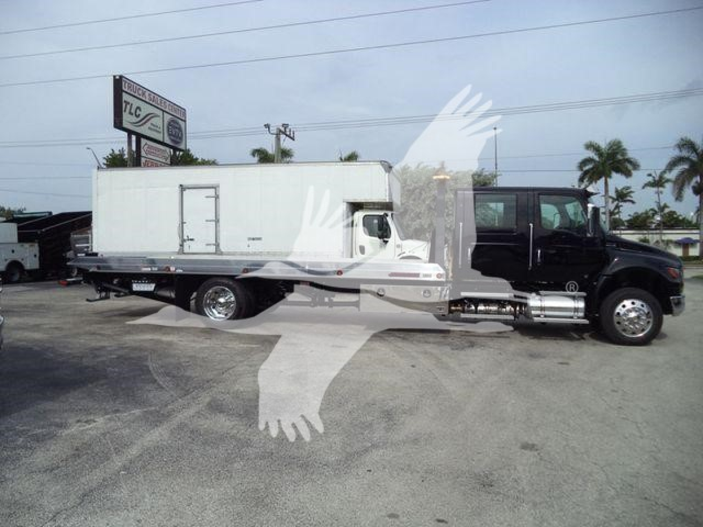 Truck in-service International MV rollback truck with a long white utility body mounted on a heavy-duty chassis