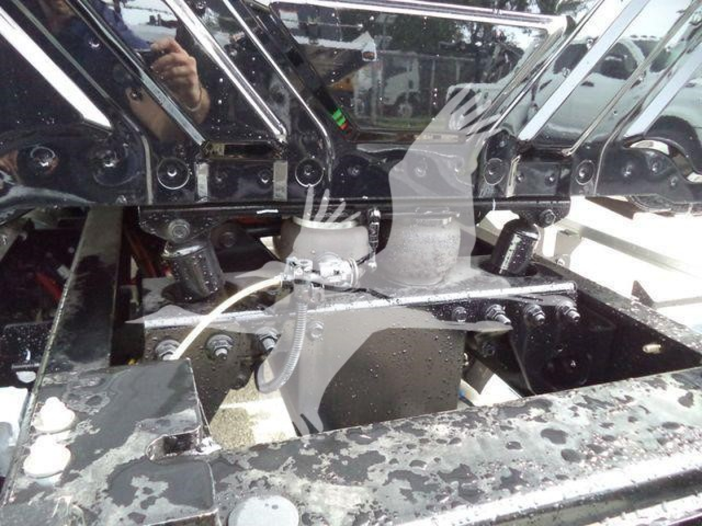 Truck chassis and engine bay components with metal framing and hoses visible (International MV)