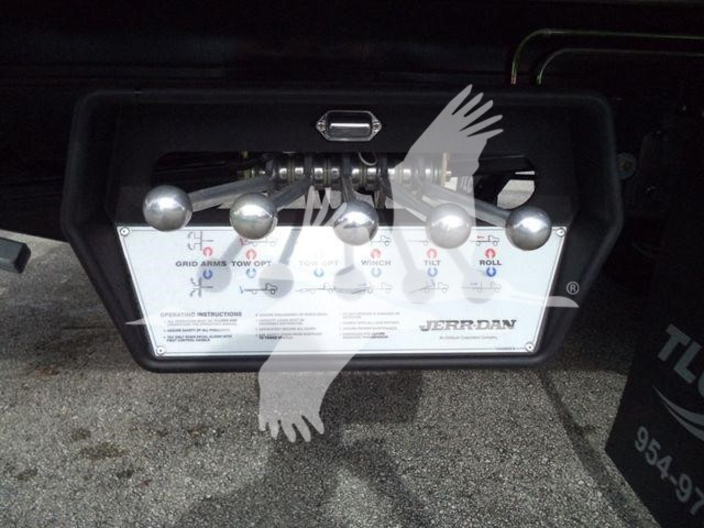 Trailer control panel with five toggle levers and label plate behind; visible text includes JERR-DAN and control instructions.
