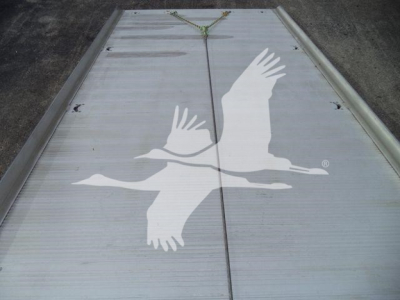 Trailer or flatbed with a large white gull graphic on a metallic surface, hanging straps at top center, showing a seagull emblem.