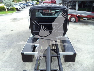 Tractor-trailer hitch area with a black metal platform and support arms, view from rear of a displacement chassis.