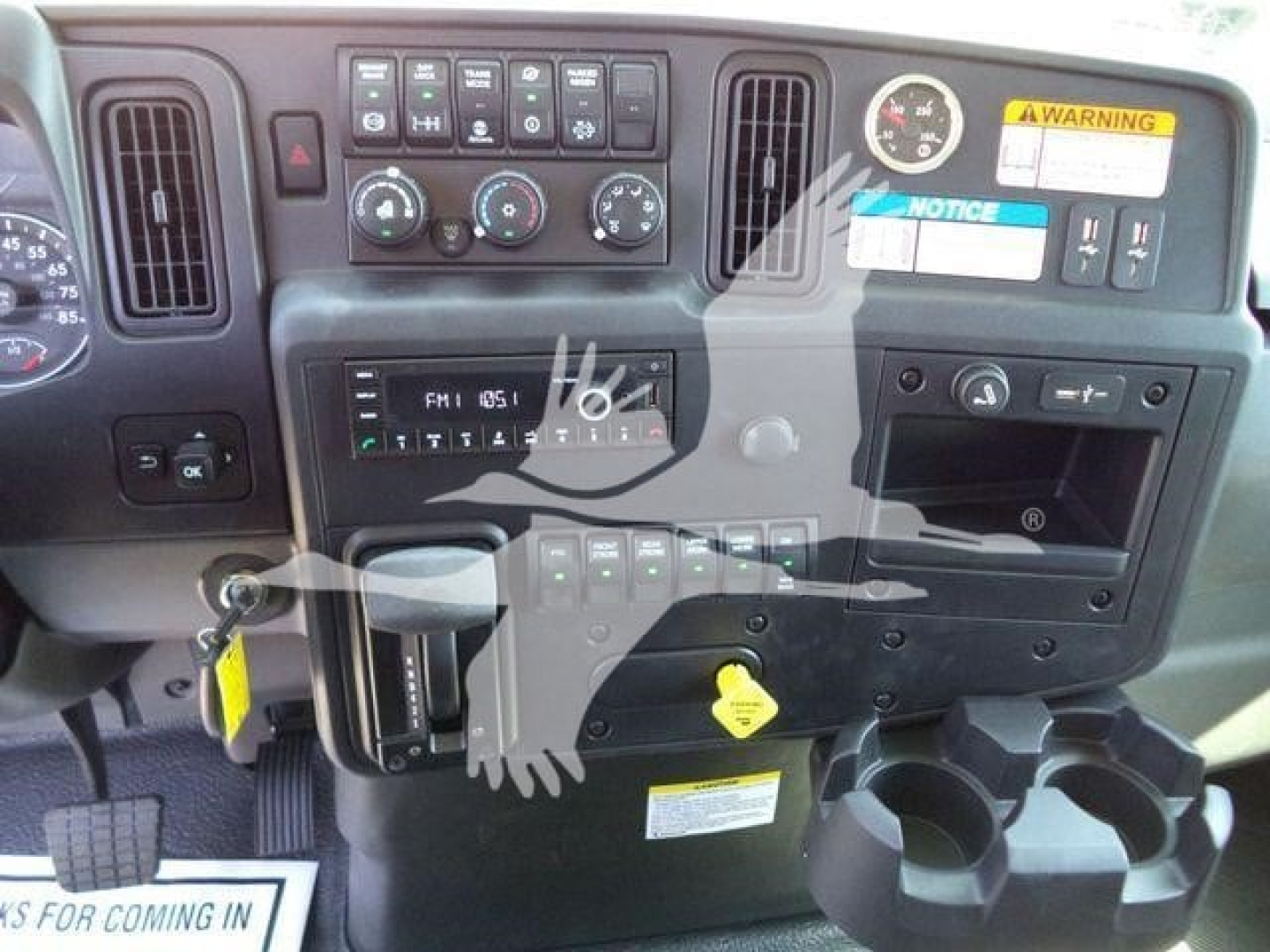 Truck dashboard view showing instrument cluster, control panels, HVAC controls, and cup holders.