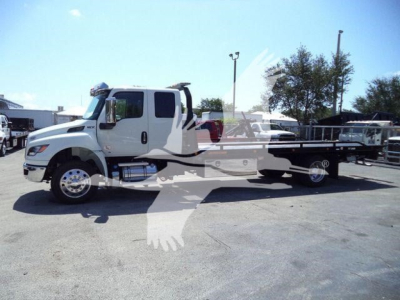 Truck chassis showing rollback tow bed attached to International MV cab, stock image with watermark and light background