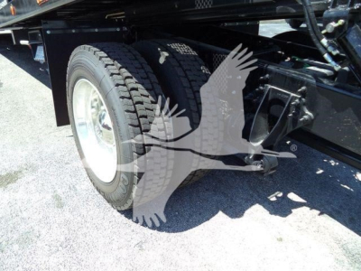 Truck rear wheel and suspension components with part of frame visible; no legible text readable