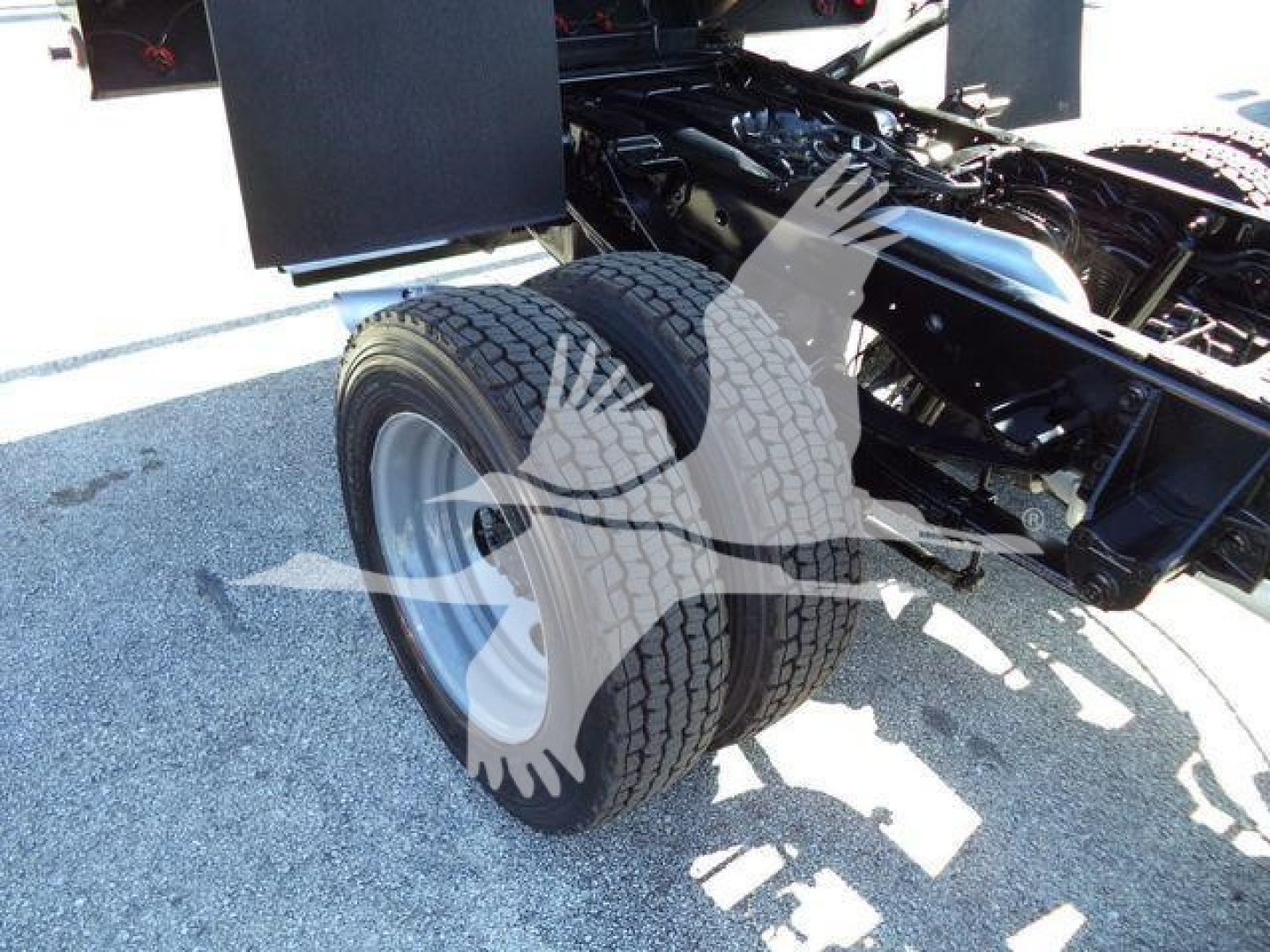 Ford F-550 chassis showing dual rear wheels and part of dump bed frame with black components.