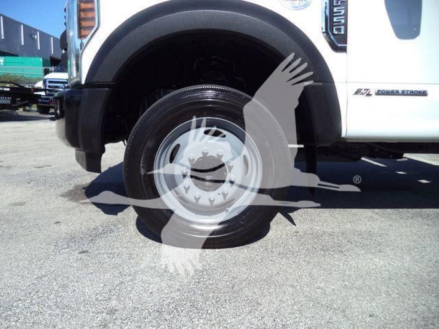 Ford F-550 dump truck front wheel and fender with logo and badge visible.