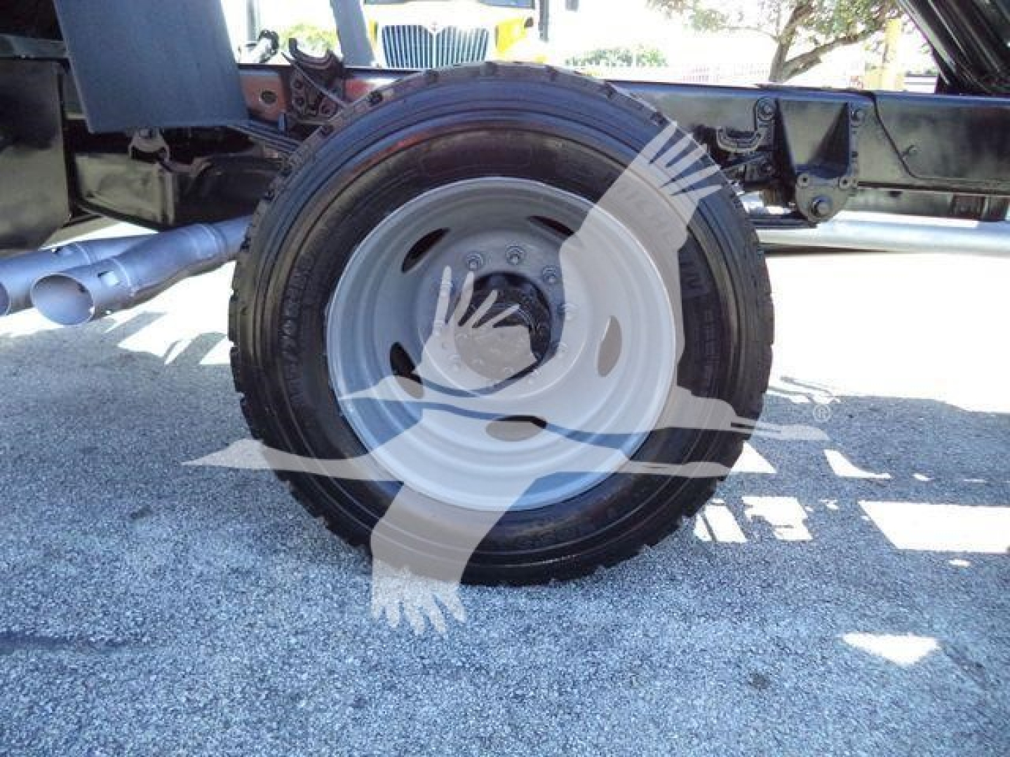 Wheel and tire on Ford F-550 dump truck chassis suspension and driveline components visible.