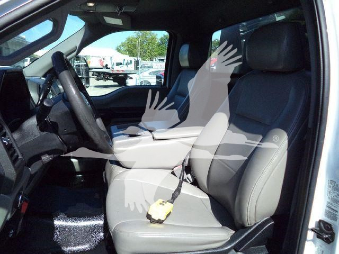 Ford F-550 interior driver seat and steering wheel view from open passenger side door.