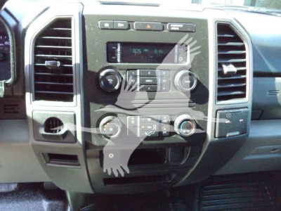 Ford F-550 dash panel showing center console with radio, climate controls, and multiple knobs; air vents on either side; dashboard in a pickup truck interior.