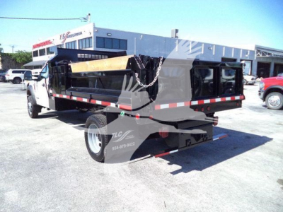 Dump truck bed attached to Ford F-550 chassis with black dump body and chain, rear view showing taillights and bumper.