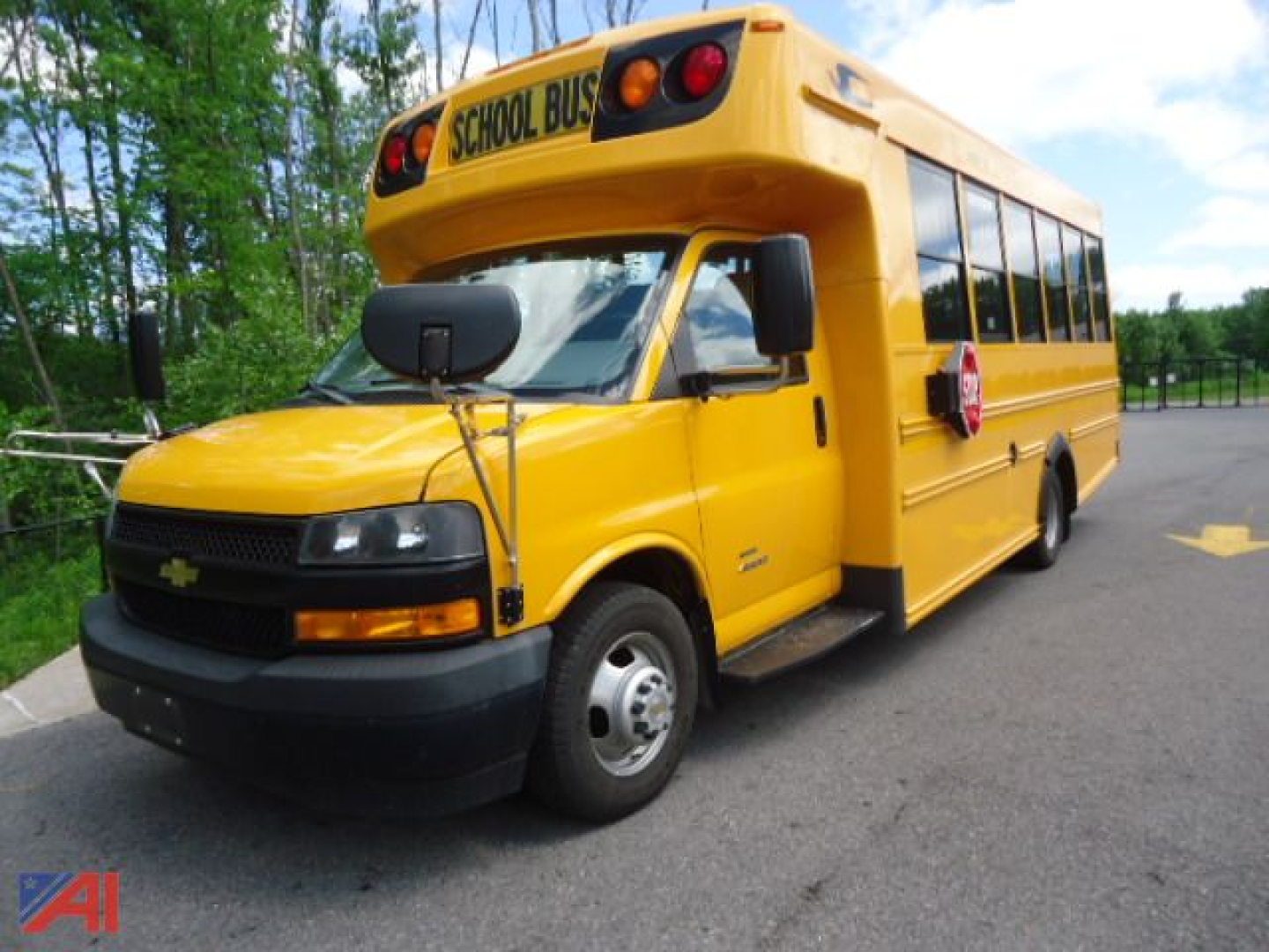 Yellow 2019 Chevrolet Express 4500 school bus with wheelchair accessibility bus equipment and 'SCHOOL BUS' sign on top front.