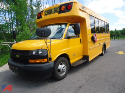 Yellow 2019 Chevrolet Express 4500 school bus with wheelchair accessibility bus equipment and 'SCHOOL BUS' sign on top front.