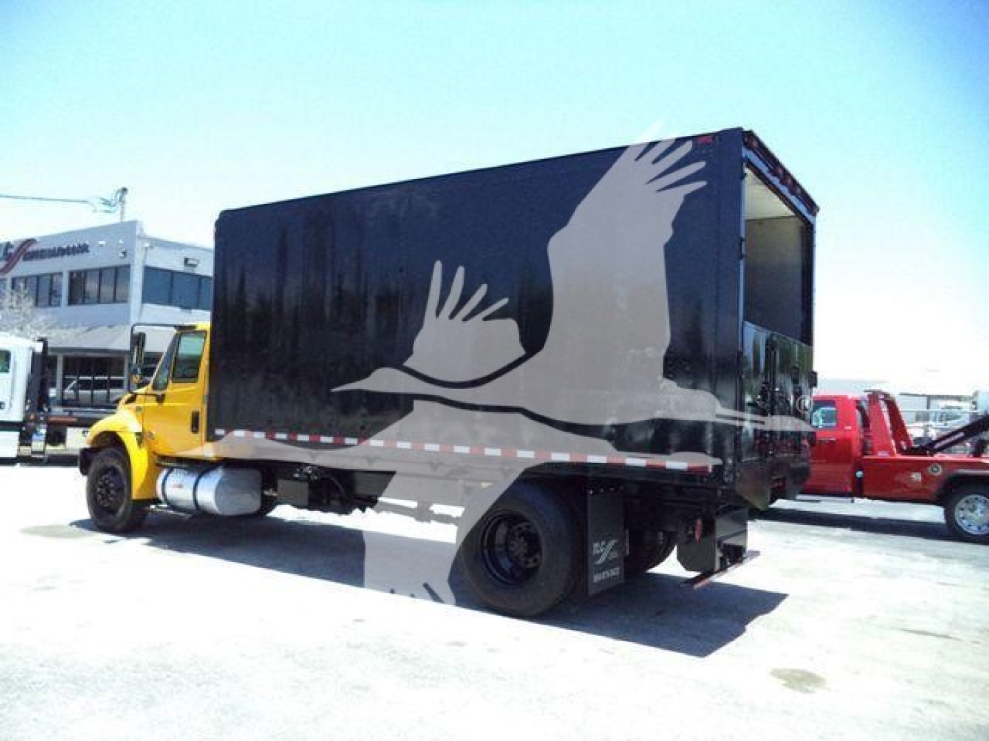 Box truck chassis with black cargo box showing stylized white birds logo and side profile view.