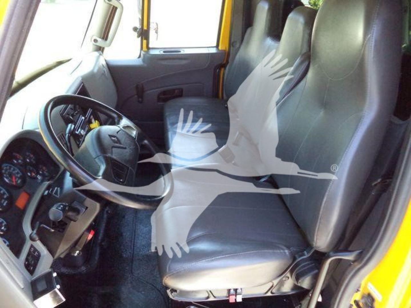 Interior of a 2019 International Durastar 4300 cab showing driver and passenger seats, steering wheel, dashboard, and front seating area.