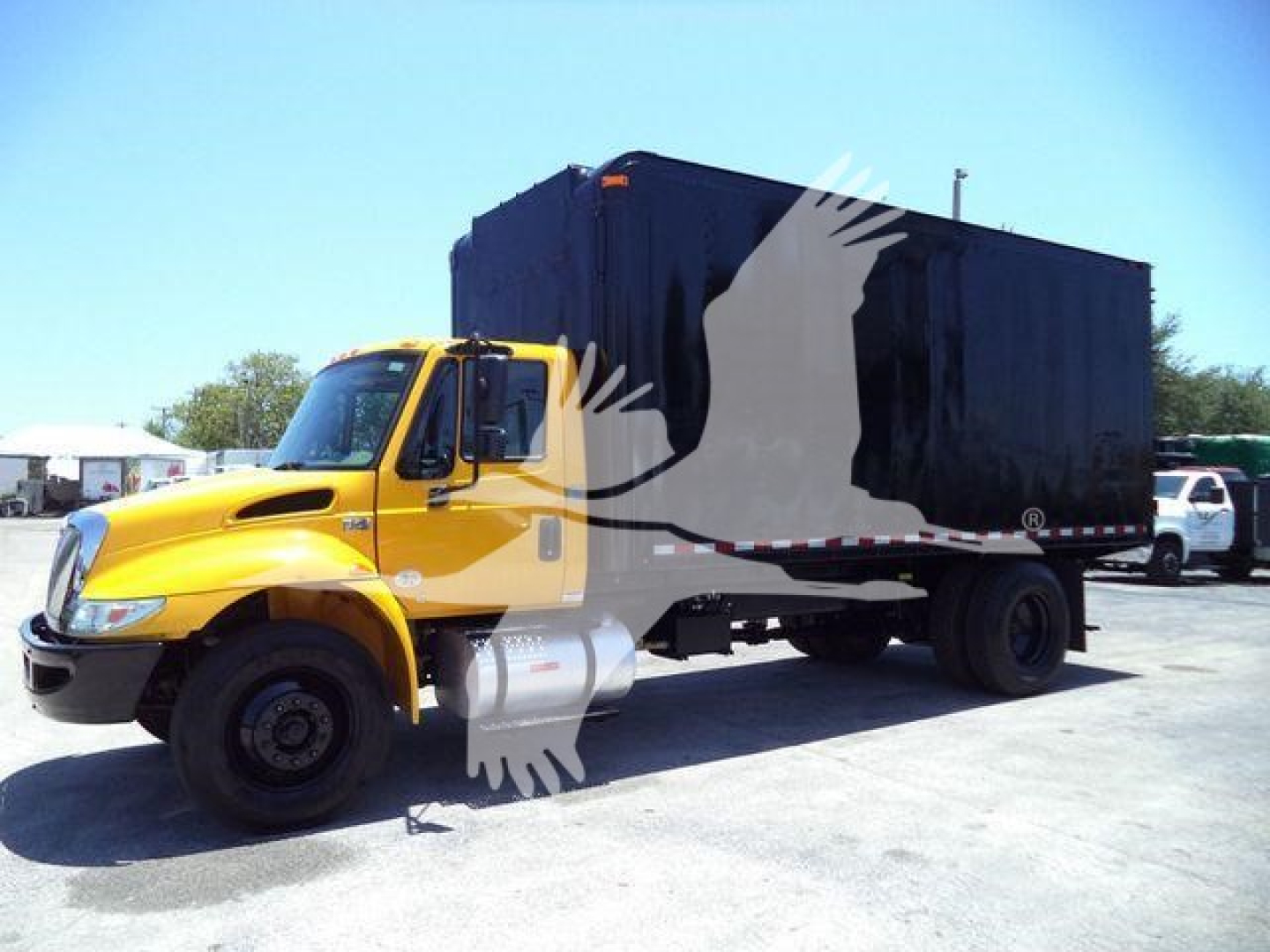 Truck rickety chassis cab with yellow front, black box body, in-service International Durastar 4300 chipper truck.