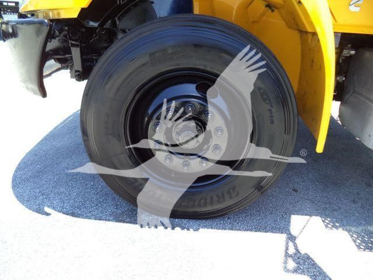 Wheel and tire close-up on a 2019 International Durastar 4300 truck chassis showing the rear tire and part of yellow body.