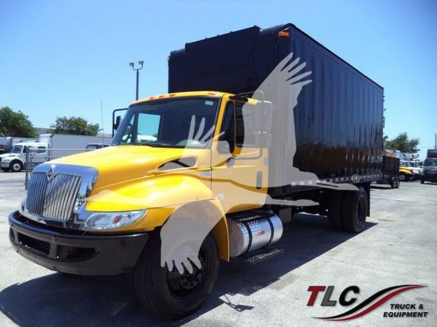 Truck c cab and dump body showing International Durastar 4300 with yellow cab and black dump, side view in a dealership lot.