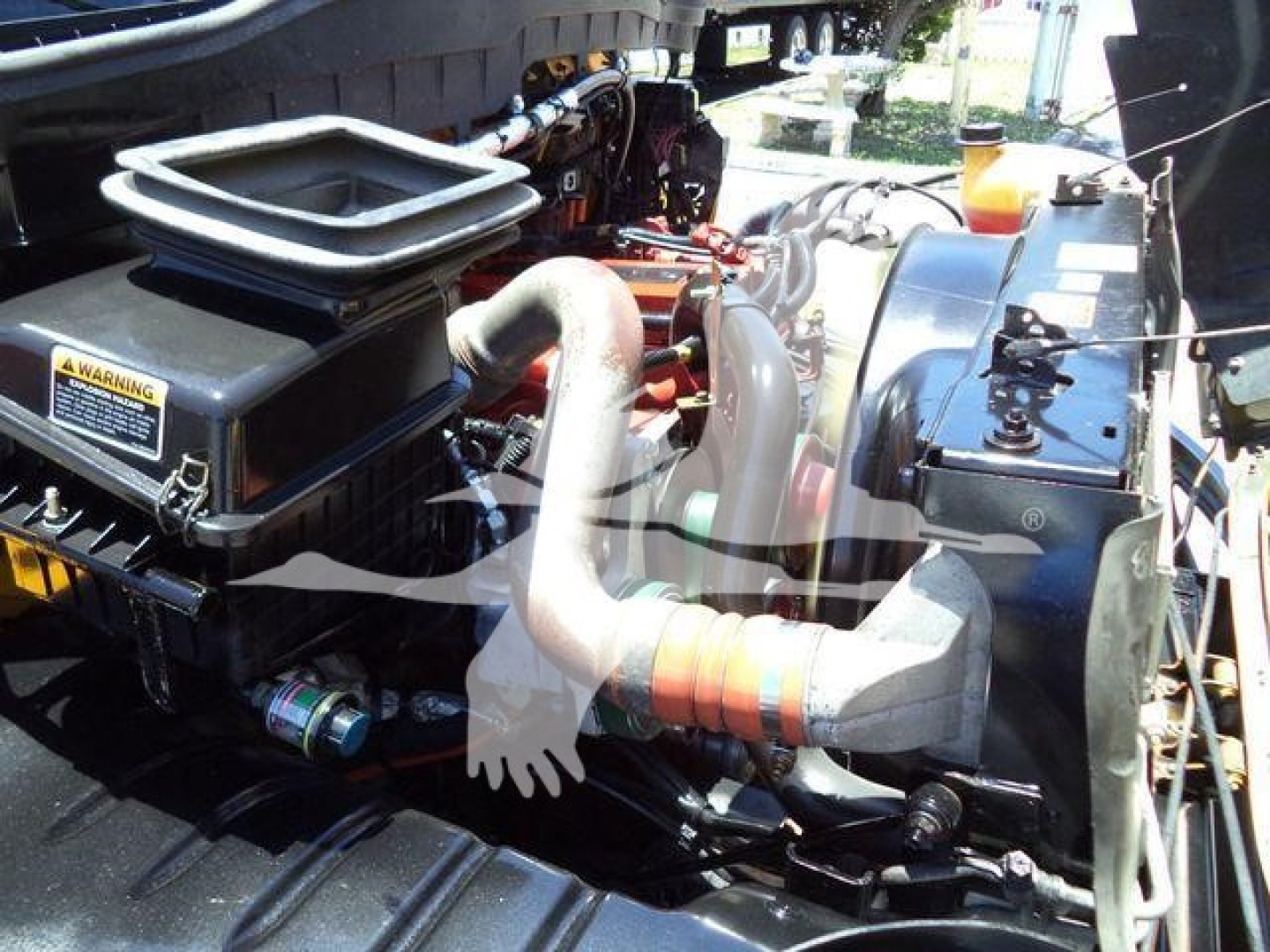 Engine bay of a 2019 International Durastar 4300 truck showing air intake, intercooler piping, and coolant reservoir.