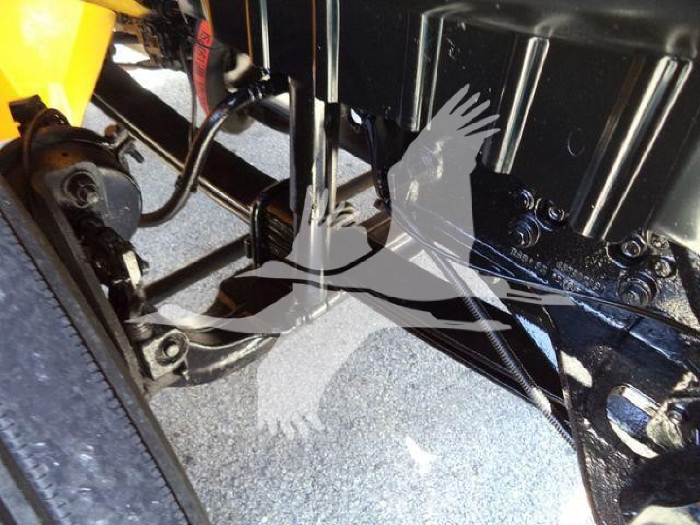 Engine bay with hydraulic components of a 2019 International Durastar 4300 truck, showing black frame, hoses, and a yellow body part visible.