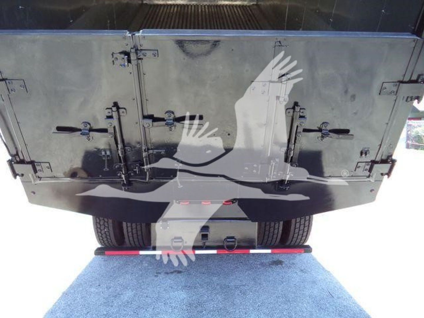 Truck rear view showing metal cargo doors and dual rear tires on a flatbed or chip truck; visible stock number area not shown.